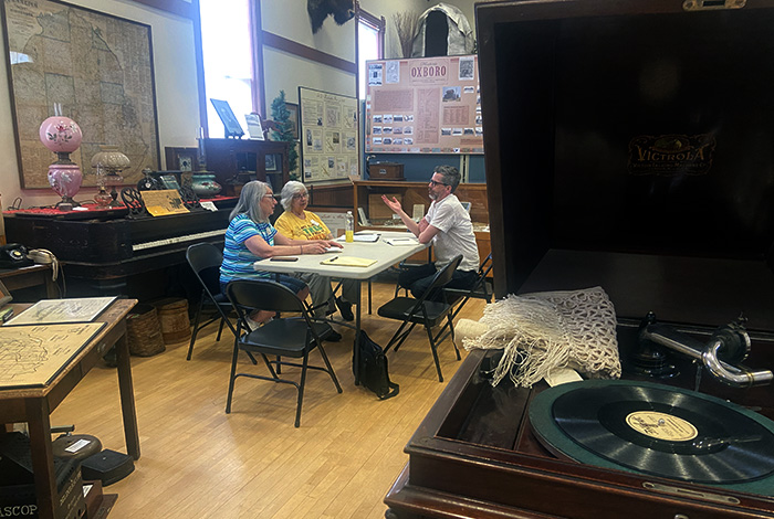 Three people discussing while sitting at a table in the middle of an exhibit